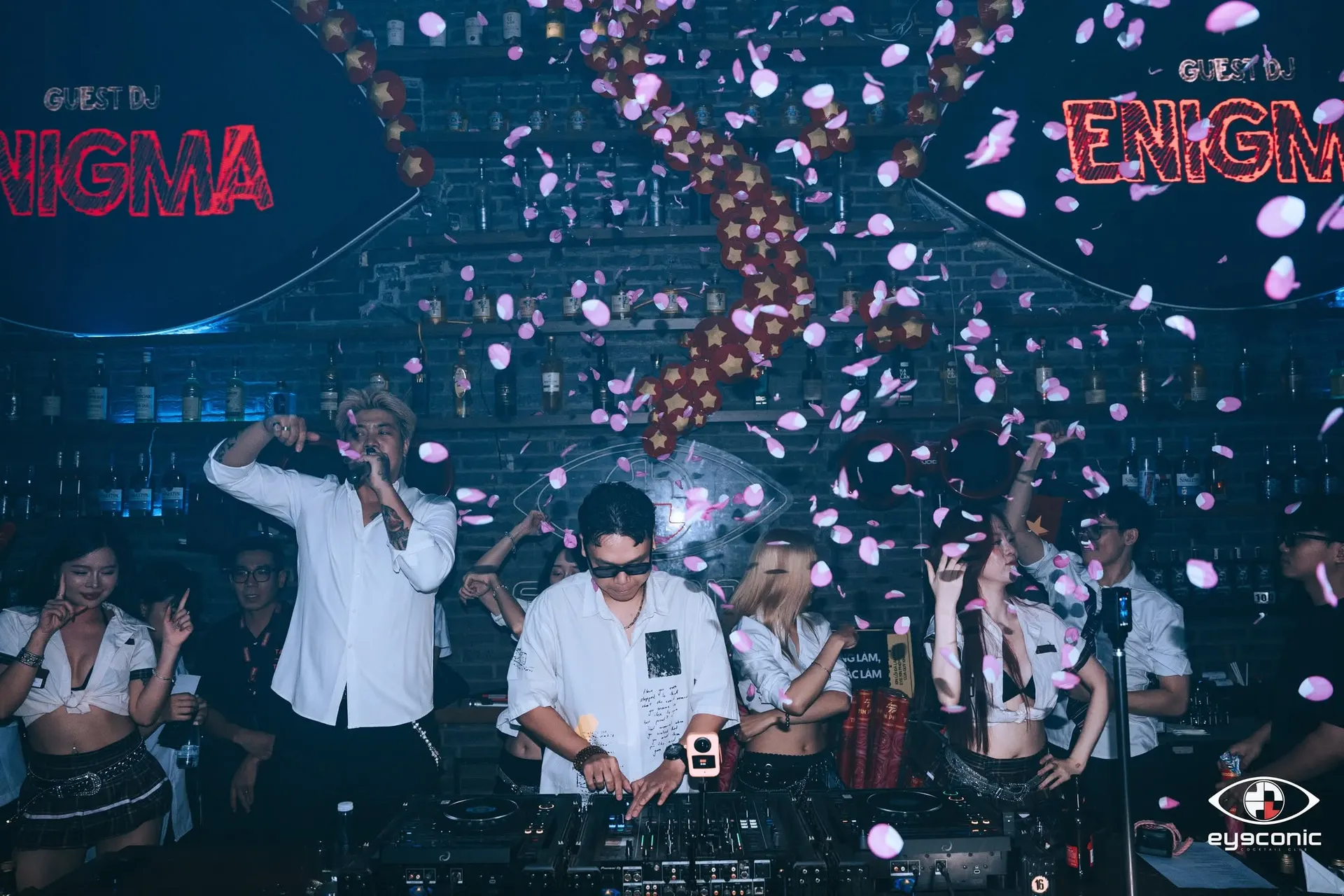 Guest DJ tại bốt Eyeconic giữa hai màn LED hình con mắt, mưa cánh hoa hồng